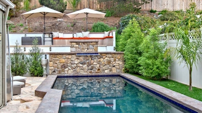 A pool with an outdoor patio seating area up above Photo